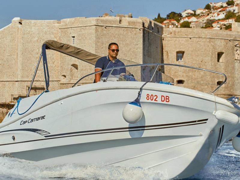 Captain Nick steering a speedboat along the Dubrovnik coastline